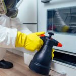 Pest Control Worker Standing With Sprayer In Kitch TY3VCXA 150x150